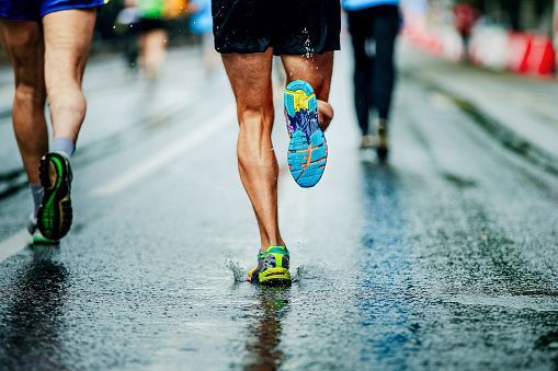 water sprays from under running shoes runner men
