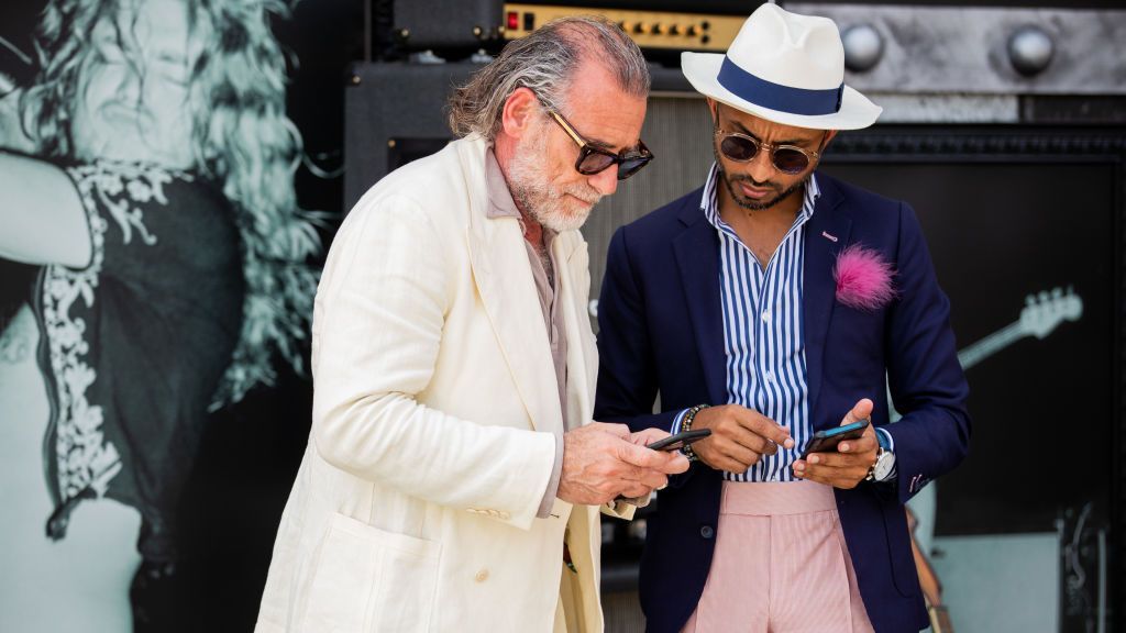 FLORENCE ITALY JUNE 11 Alessandro Squarzi is seen wearing beige suit showing something on his phone during Pitti...