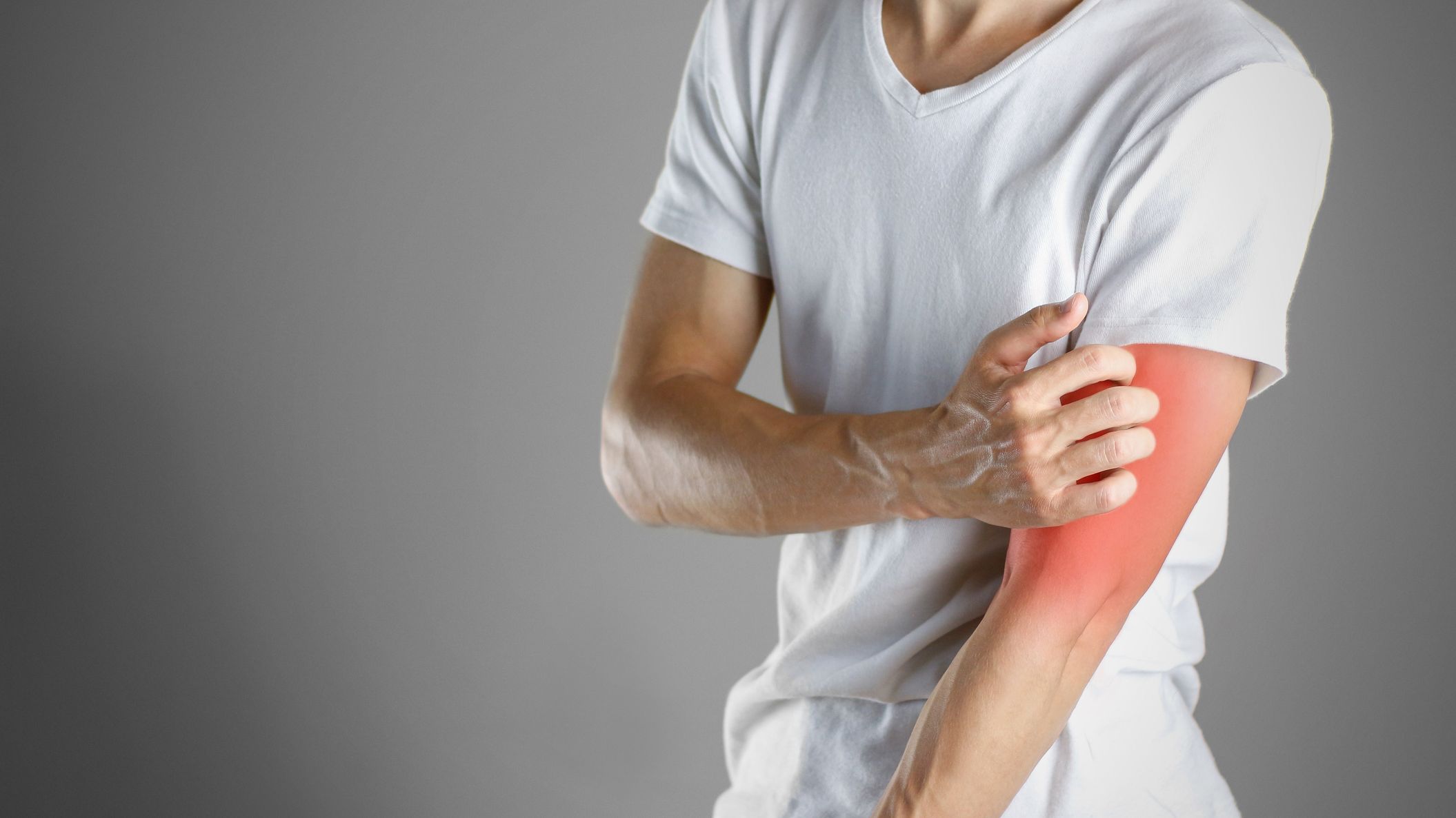 Guy in white shirt scratching his arm. Scabies. Scratch the hand. Isolated.
