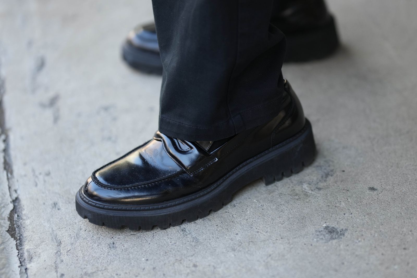 NEW YORK NEW YORK FEBRUARY 11 A guest wears black suit pants a black nylon tote bag from Prada black shiny varnished...