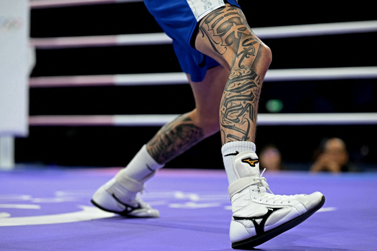Tattoos are pictured on the legs of Australia's Charlie Senior as he fights against Belgium's Vasile Usturoi in the...