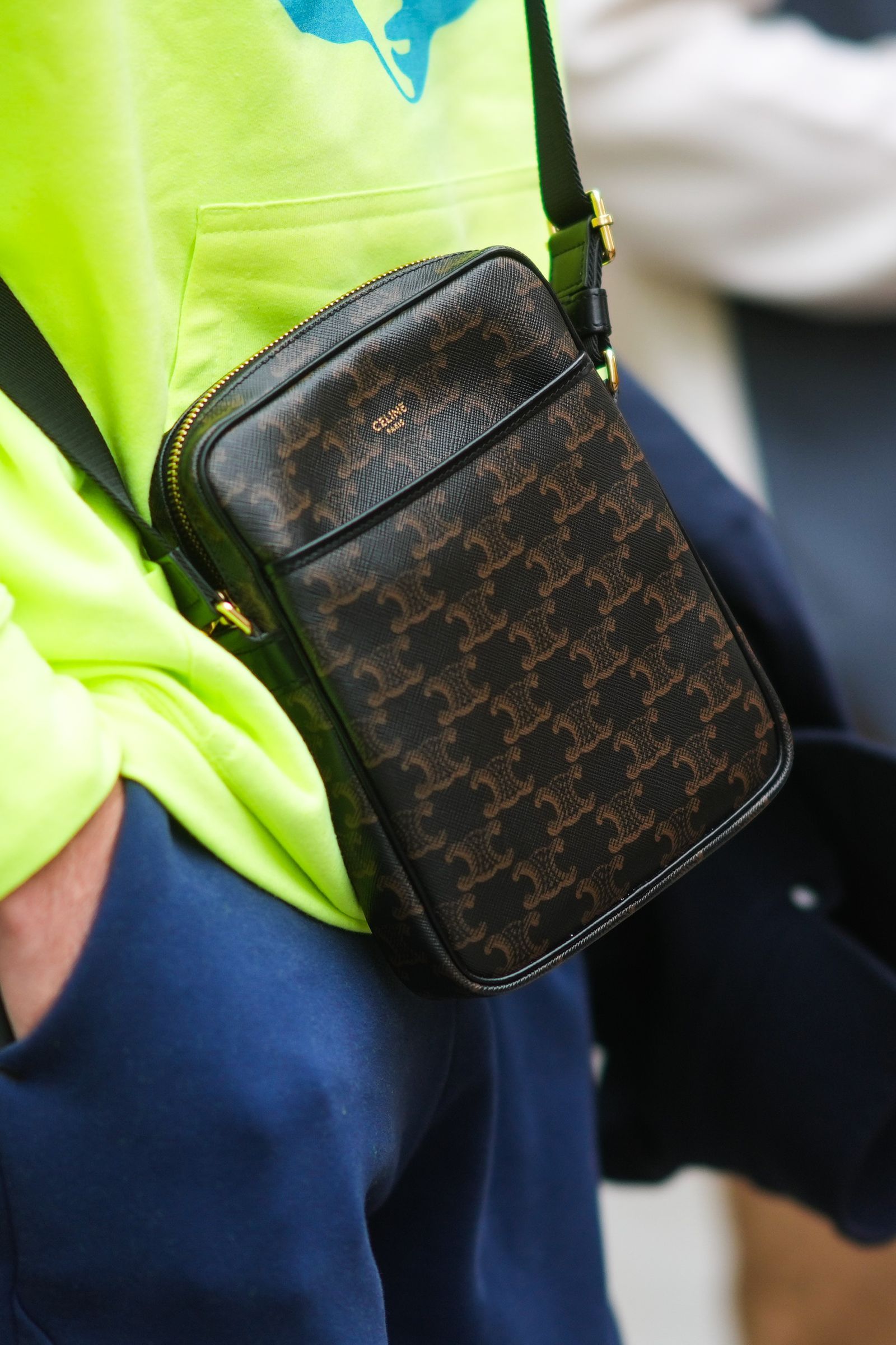 PARIS FRANCE JUNE 23 A guest wears a neon yellow hoodie sweater with a pale blue printed face a black and brown Céline...