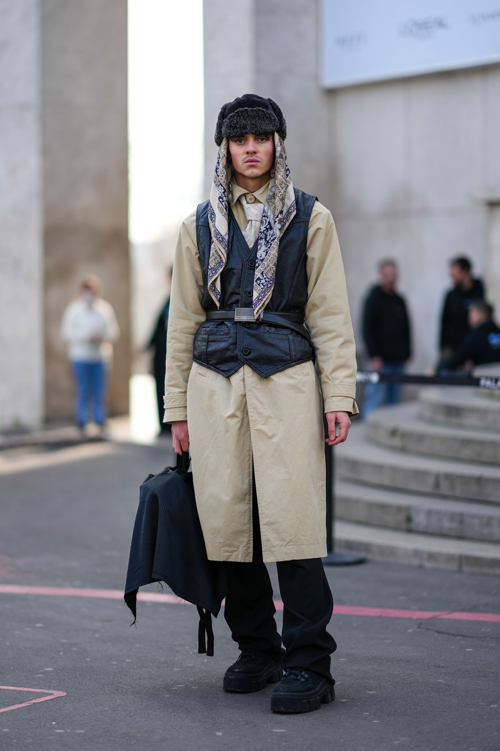PARIS FRANCE MARCH 05 A guest wears a gray fur hat a beige brown navy blue print pattern silk scarf a beige long coat...