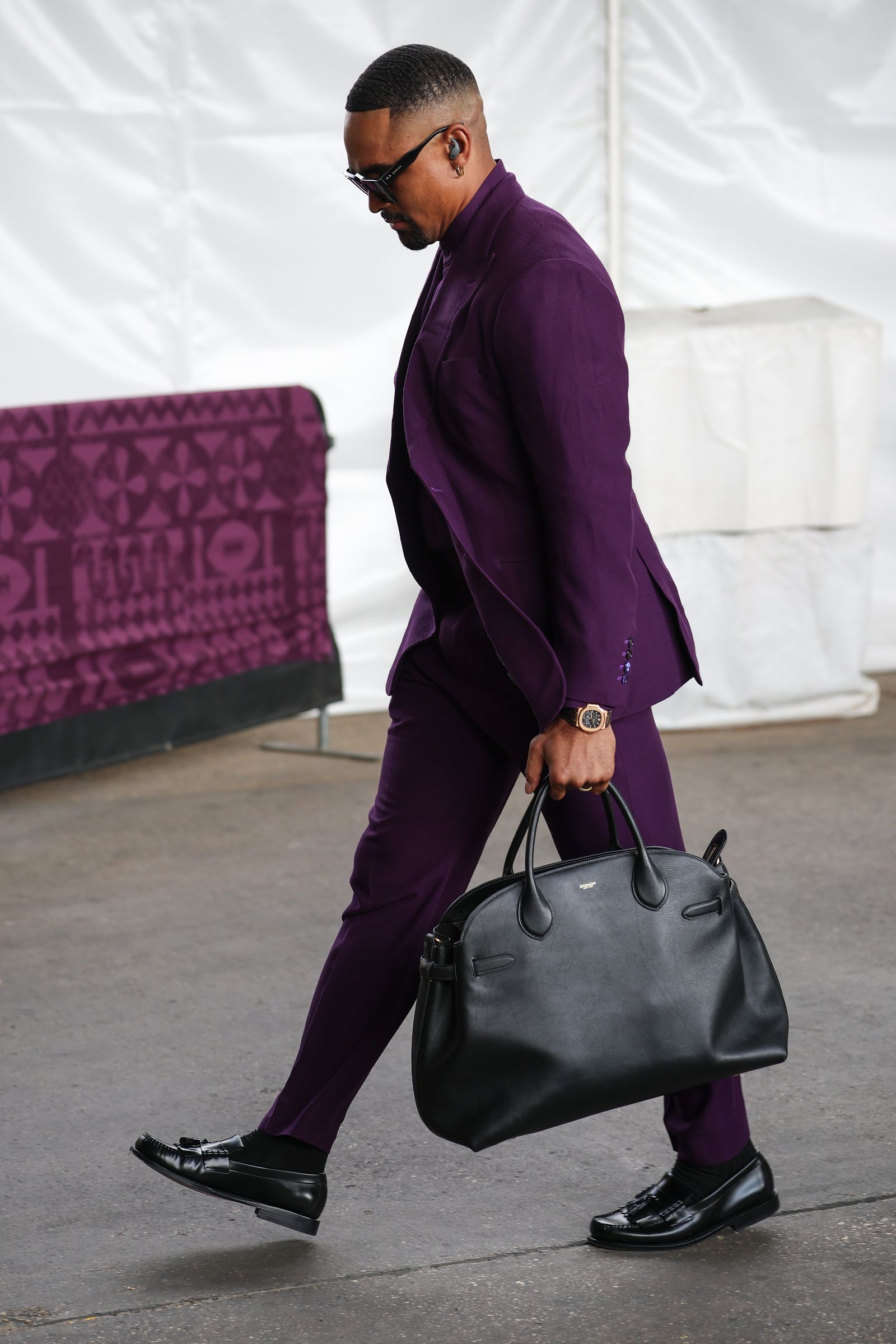 Image may contain Clothing Formal Wear Suit Accessories Bag Handbag Footwear Shoe Adult Person and Wristwatch