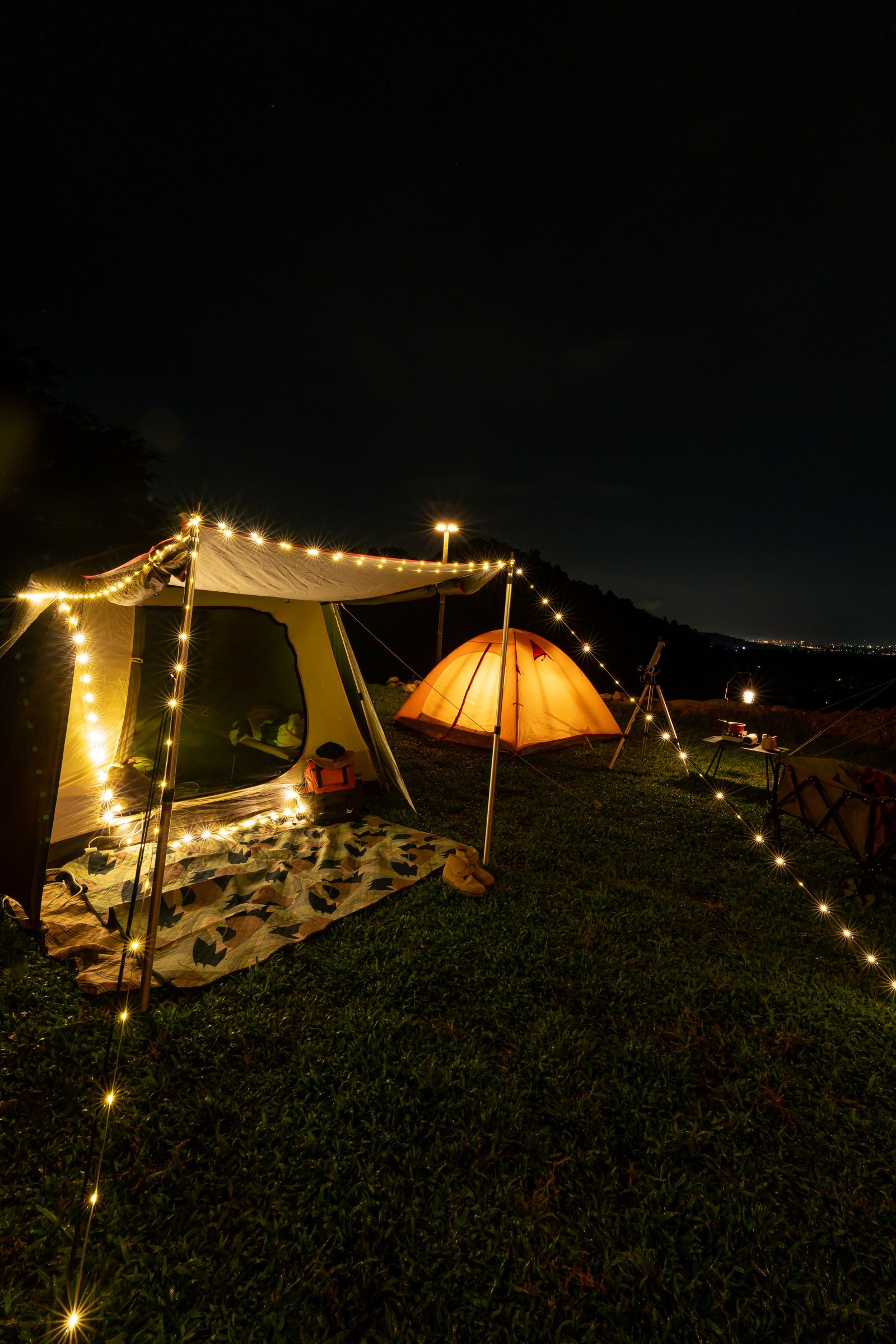Camping Tent at night time with mountain view. Outdoor activity and lifestyle.