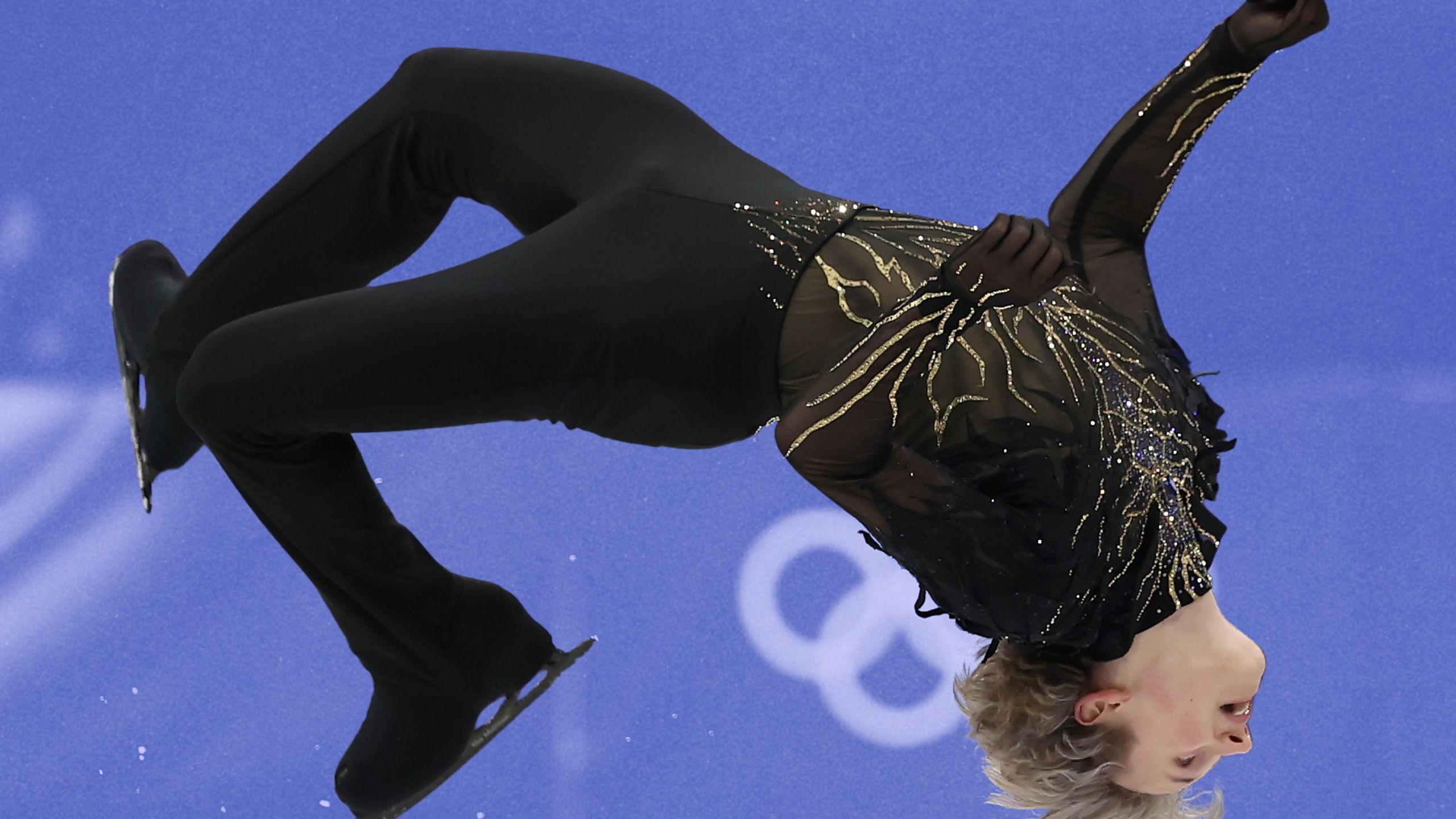 Figure skater Ilia Malin doing a backflip on ice at the 2026 Winter Olympics