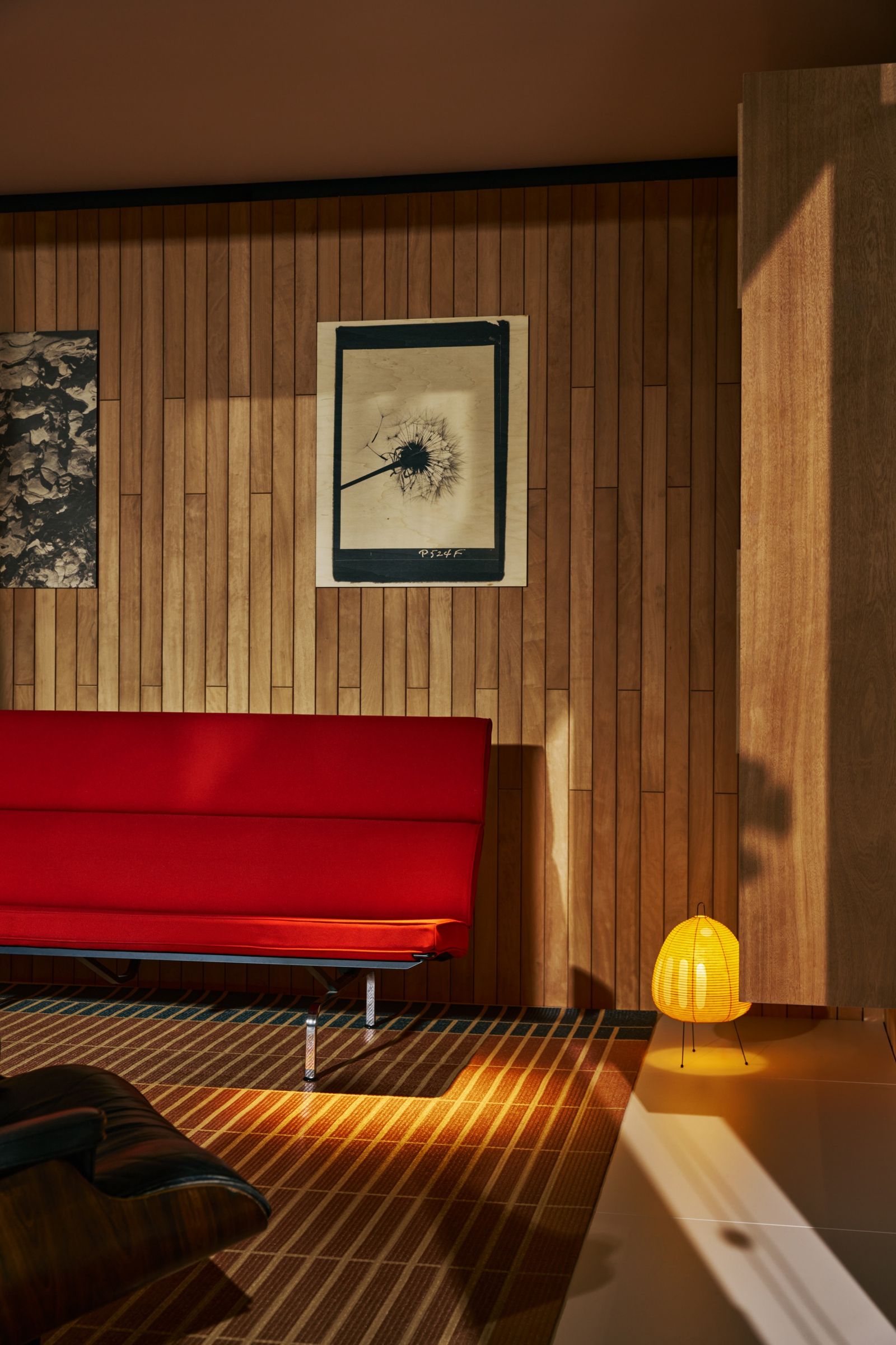 interior de una casa recubierta de madera y con un sof rojo