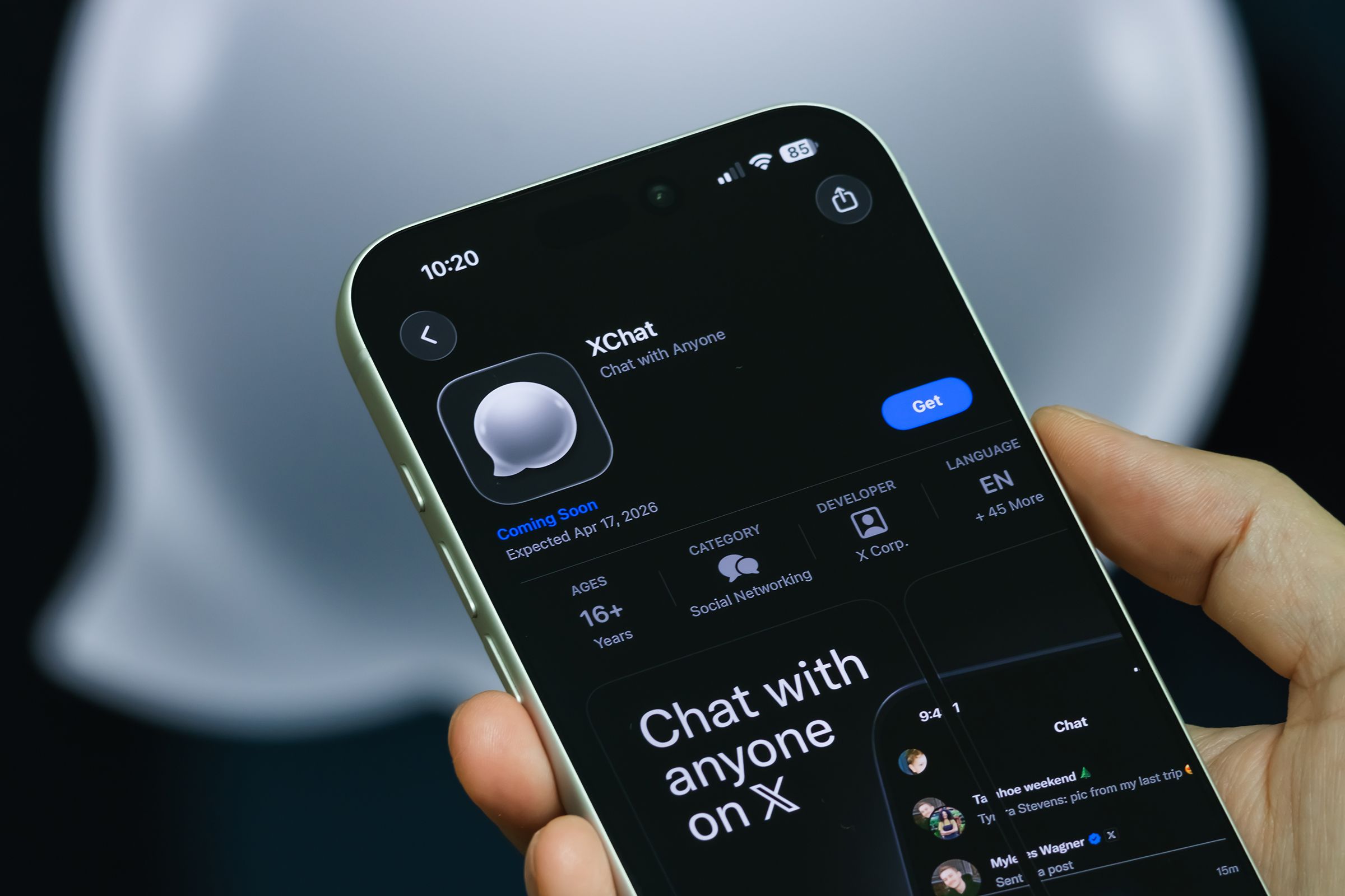 A person holding an iPhone with the XChat app seen in the App storre